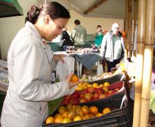 O feirante Felipe Oliveira cuida da banca de verduras, legumes, vegetais e frutas