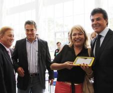 Ao lado do 1º secretário sa Assembléia Legislativa do Paraná, deputado Plauto Miró, o presidente Jacson Carvalho Leite observa a entrega de um tablet feita pelo governador Beto Richa, a uma professora da rede estadual do ensino.