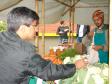 O feirante Felipe Oliveira cuida da banca de verduras, legumes, vegetais e frutas