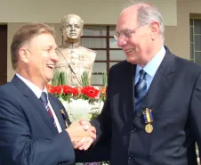 Jacson e Lucio cumprimentam-se diante do busto do coronel Joaquim Antonio de Moraes Sarmento