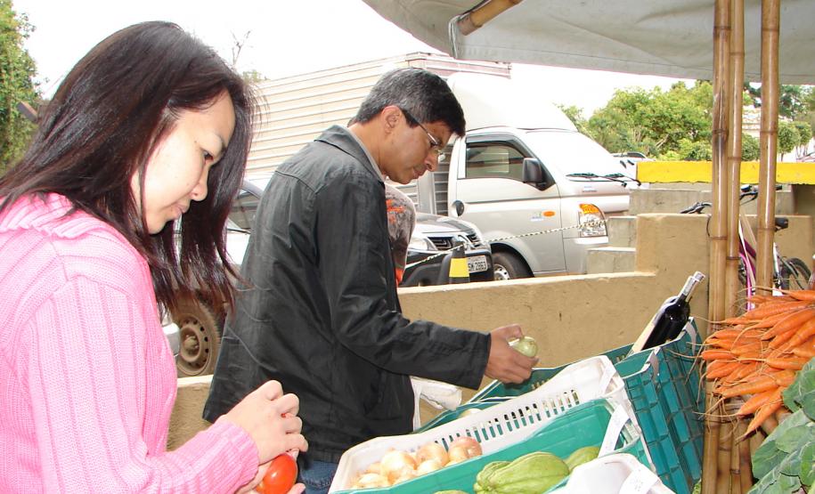 O feirante Felipe Oliveira cuida da banca de verduras, legumes, vegetais e frutas