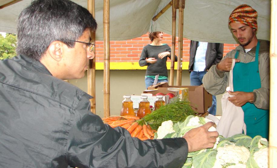 O feirante Felipe Oliveira cuida da banca de verduras, legumes, vegetais e frutas