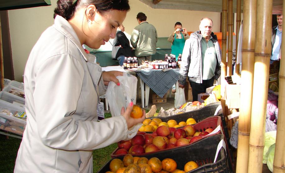 O feirante Felipe Oliveira cuida da banca de verduras, legumes, vegetais e frutas