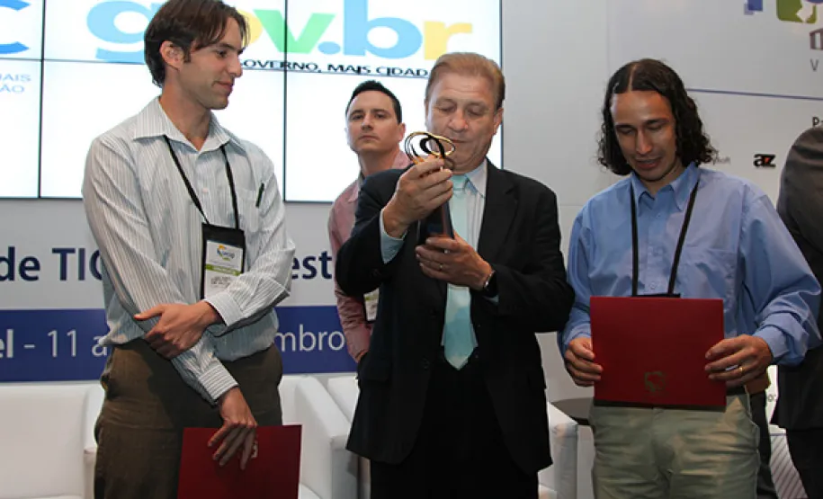 Celepar recebe prêmio Excelência em Governo Eletrônico Presidente Jacson Carvalho Leite (ao centro) ao lado dos analistas Luis Alberto Menon de Araújo e Dirceu Grein, recebem o prêmio e-Gov 2013