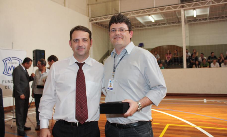 O presidente da Funcel, Antonio Carlos Wolf Jr entrega a homenagem de 25 anos a Mário Moraes Jr