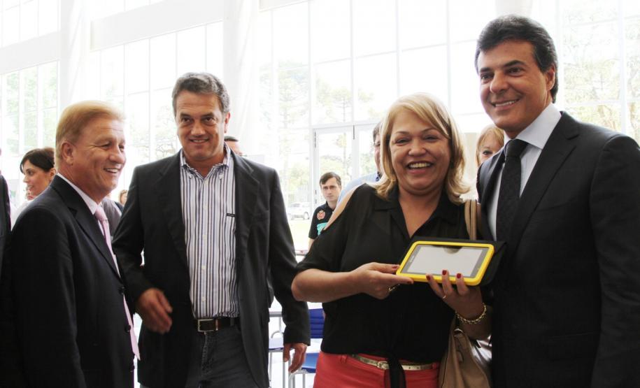 Ao lado do 1º secretário sa Assembléia Legislativa do Paraná, deputado Plauto Miró, o presidente Jacson Carvalho Leite observa a entrega de um tablet feita pelo governador Beto Richa, a uma professora da rede estadual do ensino.
